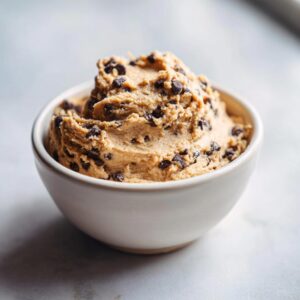 A bowl of creamy high protein cookie dough loaded with mini chocolate chips.