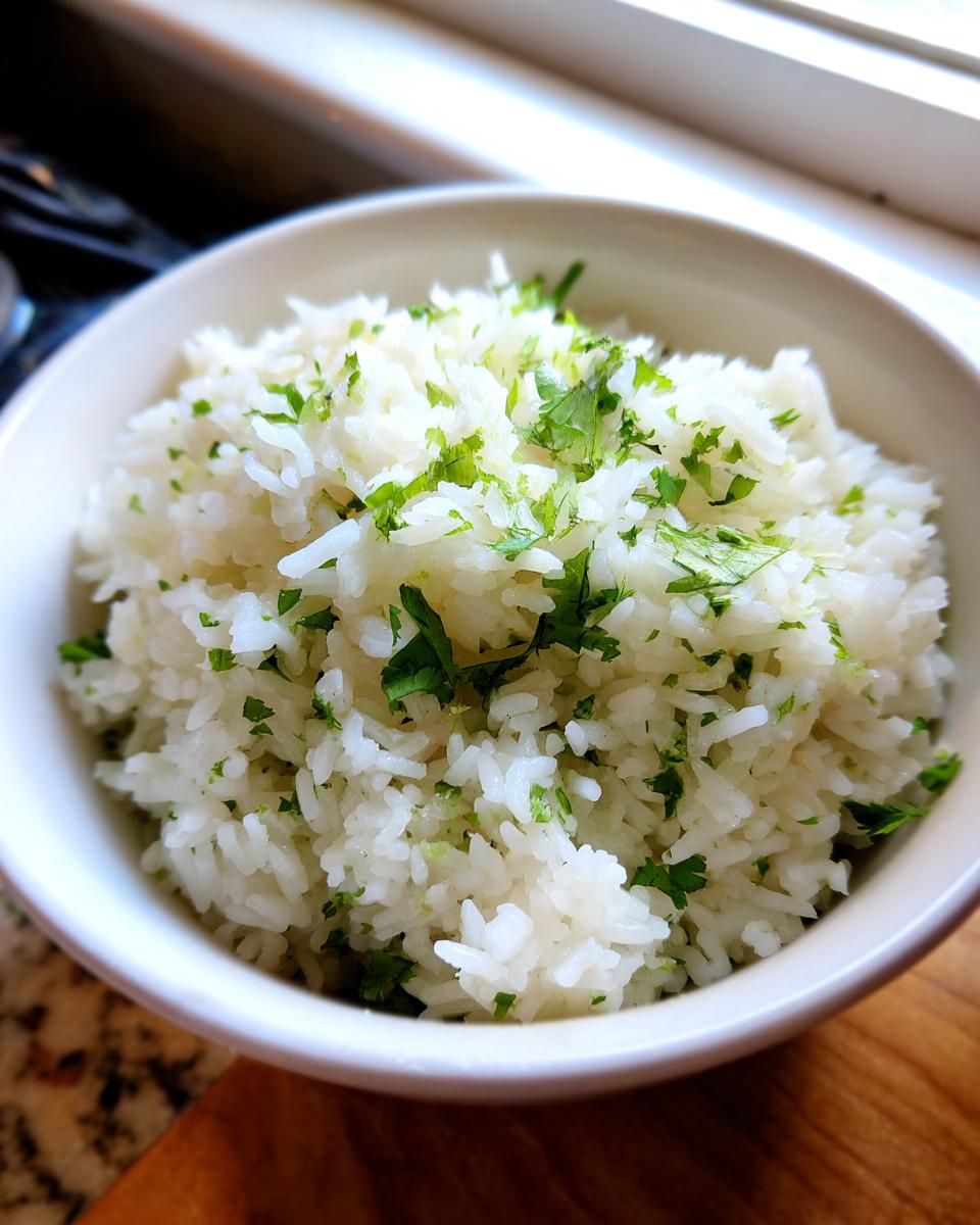 A close-up of fluffy cilantro lime rice in a white bowl, garnished with fresh cilantro.