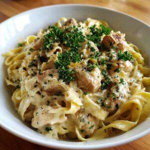 A close-up of creamy garlic parmesan chicken pasta topped with fresh parsley.