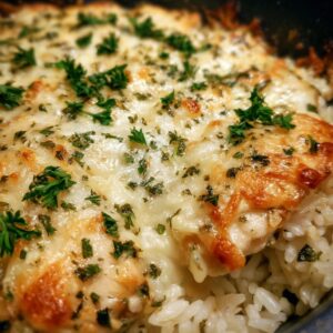 Close-up of a French onion chicken rice bake with melted cheese and parsley.