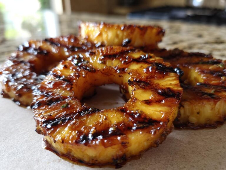 Close-up of juicy, caramelized grilled pineapple rings with distinct grill marks.
