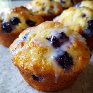 Close-up of a Starbucks blueberry scone with a sweet white glaze drizzled over the top.