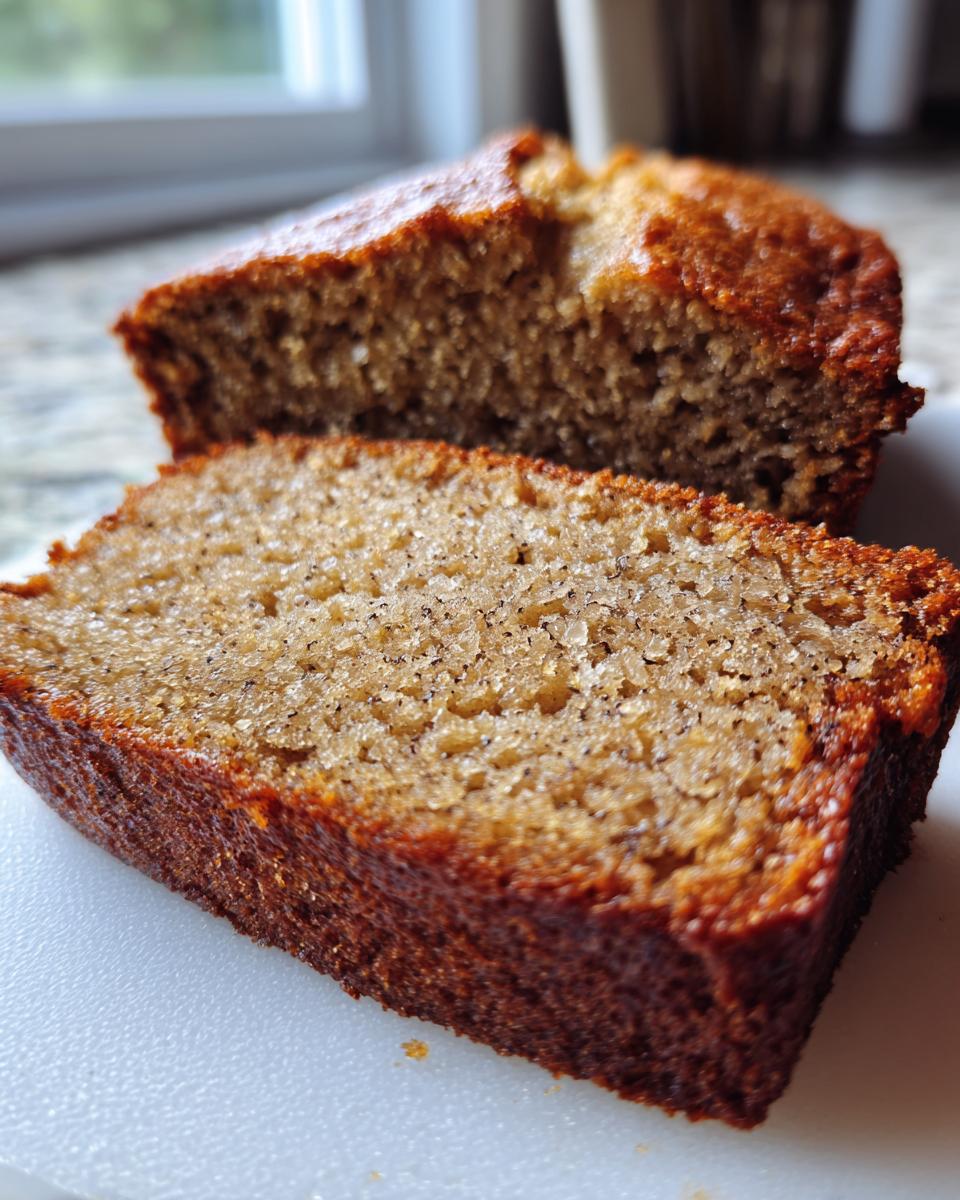 Close-up of two moist slices of banana bread, showcasing the texture and banana specks.