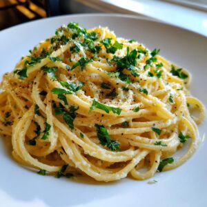 Close-up of creamy spaghetti coated in garlic parmesan sauce, topped with fresh parsley and black pepper.