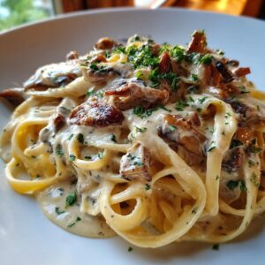Close-up of creamy mushroom pasta tossed in a rich white sauce and garnished with fresh parsley.