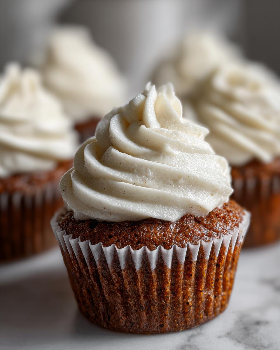 Close-up of a moist gingerbread cupcakes topped with a swirl of vanilla bean frosting.