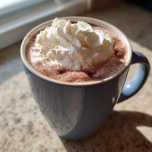 A close-up of a mug filled with rich white hot chocolate topped generously with whipped cream.