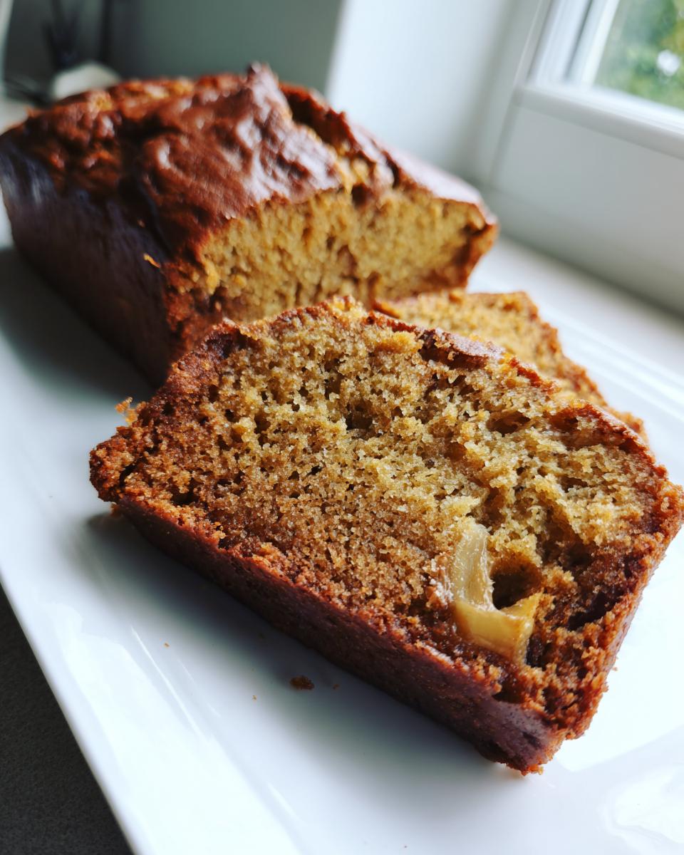 Close-up of a moist slice of the best banana bread showing its crumb texture and a piece of banana inside.
