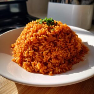 A mound of vibrant, reddish-orange smoky jollof rice garnished with fresh parsley on a white plate.